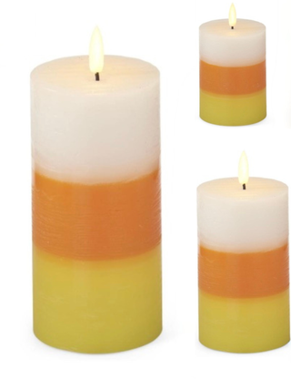 Set of 3 LED pillar candles with layered white, orange, and yellow wax; lit flames