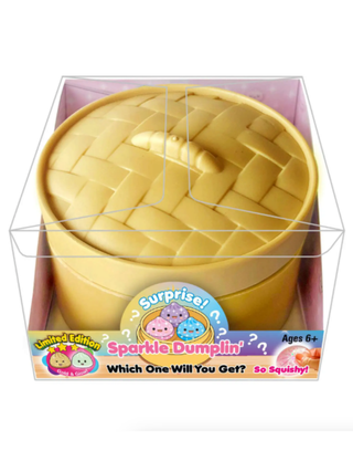 Yellow woven squishy dumpling toy in yellow base with capsule packaging