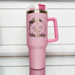 Light pink gold-accent tumbler with clear lid, side handle, and front logo.