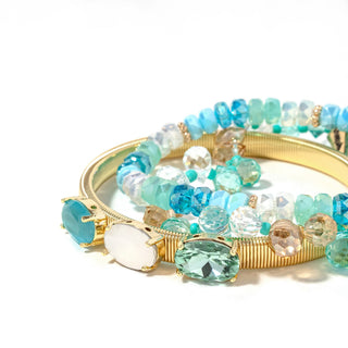 Gold-tone bracelet stack with aqua, light teal, and clear faceted beads