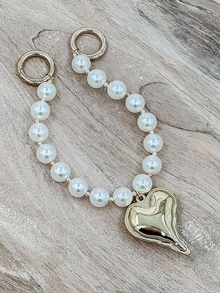 Gold-tone pearl bag chain with round white pearls and heart pendant clasp
