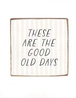 Wood block sign with "These Are The Good Old Days" handwritten black text