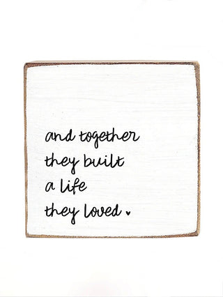 Wood block sign with script quote: "and together they built a life they loved"