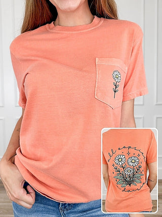 Orange short-sleeve graphic tee with chest pocket and flower detail