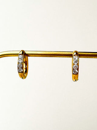 Gold huggie hoop earrings with clear crystal row on gold-tone hoops