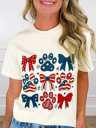 Cream cotton short-sleeve graphic tee with red and blue bows and stars