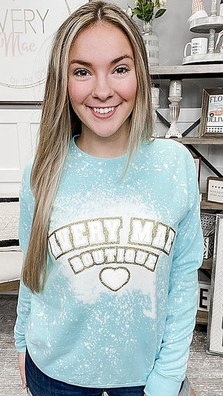 Light blue bleached crewneck sweatshirt with “VERY MAE” lettering and heart