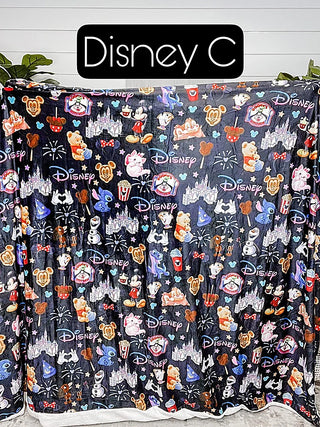 Black sherpa blanket with multicolor Disney character and logo print
