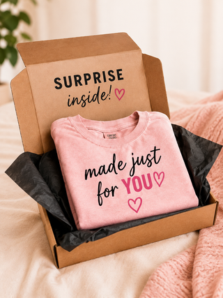 Avery Mae Graphic Club subscription box with a folded Comfort Colors graphic tee and Surprise Inside packaging