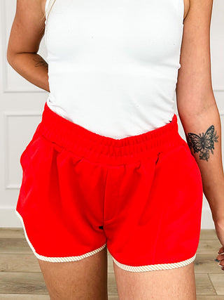 Red high-rise knit shorts with elastic waistband and ruffled hem detail