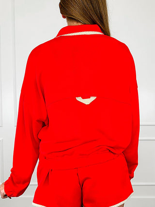 Red long-sleeve pullover top, back view with small white logo patch