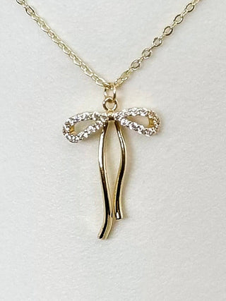 Gold bow pendant necklace with glittery bow and long drop charms on chain