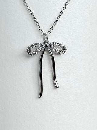Silver bow pendant necklace with glittery bow and long drop charms on chain