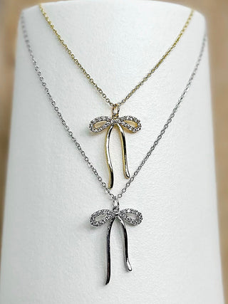 Bow pendant necklace with gold-tone chain and two bow charms, one above and one below