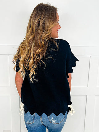 Black short-sleeve sweater top with ruffled sleeves and side view