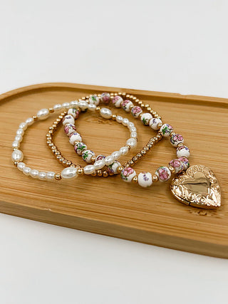 Bracelet set with pink/white beads, gold accents, and a heart charm