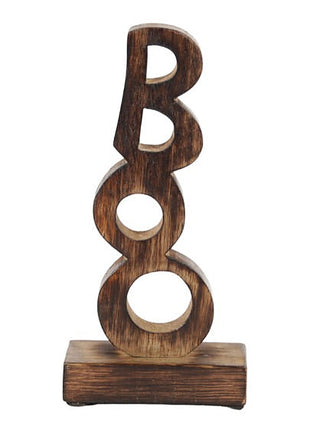 Wooden letter B decor with three circular cutouts on stacked wood