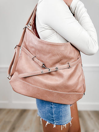 Pink faux leather convertible backpack bag with adjustable shoulder straps and front buckle detail