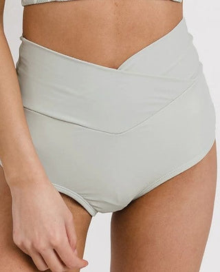 High-rise light-colored swim bottoms with ruched waistband and V-shaped front seam