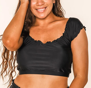 Black swim top with scalloped neckline and ruched cap sleeves