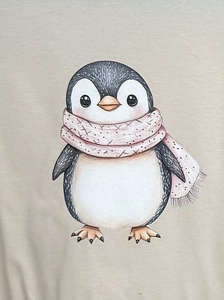 Cream short-sleeve graphic tee with cartoon penguin wearing a pink scarf