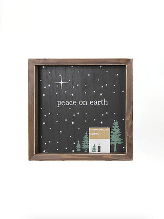 Wood peace-on-earth sign with starry night background, Christmas trees, and small house