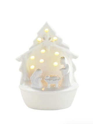 Ceramic light-up shelf sitter shaped like a white house with glowing windows