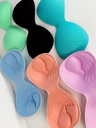 Assorted padded bra cups in black, teal, blue, orange, mauve, and peach tones