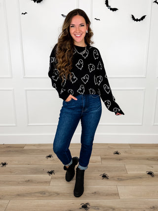 Model wears a black ghost print knit sweater with Judy Blue Kyla jeans and black booties.