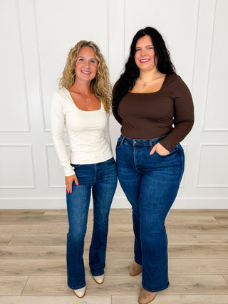 Fitted square neck long sleeve top in bone and brown worn with dark wash bootcut jeans and cream booties.