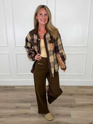 Brown plaid shacket with floral pocket and button front, paired with wide-leg dark olive denim pants