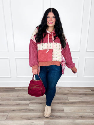 Burgundy patchwork hooded top with dark wash skinny jeans and a burgundy crossbody bag.