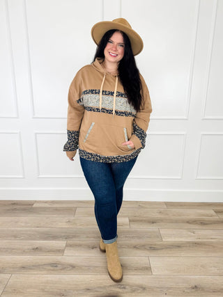 Camel hooded top with navy and cream floral trim worn with dark wash skinny jeans, tan booties and a camel hat.