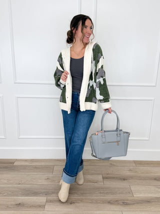 Camo sleeve hooded cardigan over blue denim jeans with wide legs and tan boots
