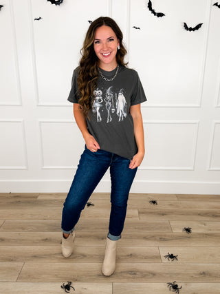 Model wears a grey Classic Costume Party graphic tee with Judy Blue Kyla jeans and cream booties.