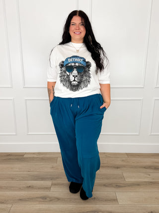 White Detroit graphic long-sleeve tee with teal wide-leg pants, relaxed fit