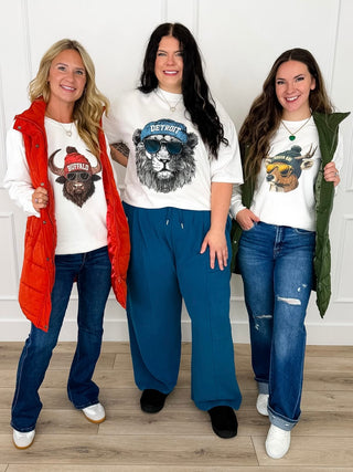 Three Game Day Gear graphic tees and sweatshirts in Buffalo, Detroit, and Green Bay prints with jeans and puffer vests.