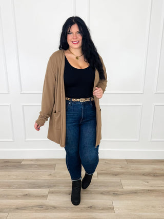 Latte brown button up cardigan worn open over a black tank with dark wash skinny jeans, a leopard belt and black booties.
