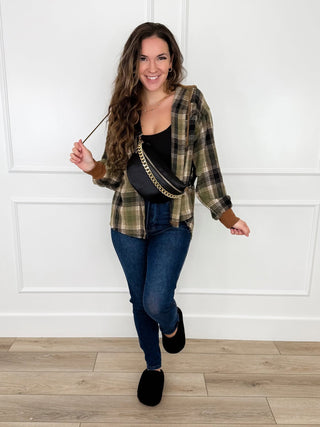 Olive plaid hooded flannel shacket with blue skinny jeans, front open, long sleeves
