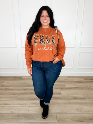 Orange long-sleeve floral graphic tee with “vibes” print on the front.