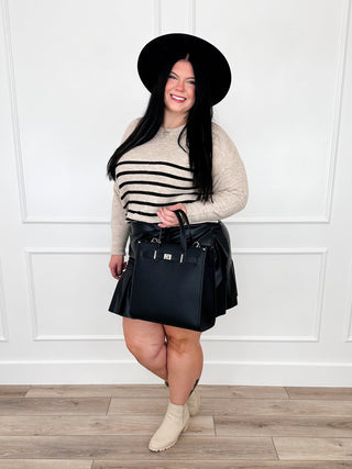 Women's striped sweater and dark faux leather mini skirt outfit