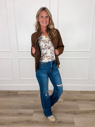 Brown quilted jacket over tan leaf print top and blue distressed jeans outfit