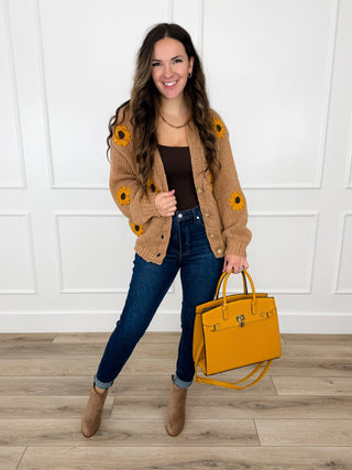 Tan chunky knit cardigan with crochet sunflowers worn over a brown tank with dark wash skinny jeans and taupe booties.
