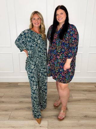 Teal floral wide leg jumpsuit and black paisley Gabby dress shown together for fall styling.