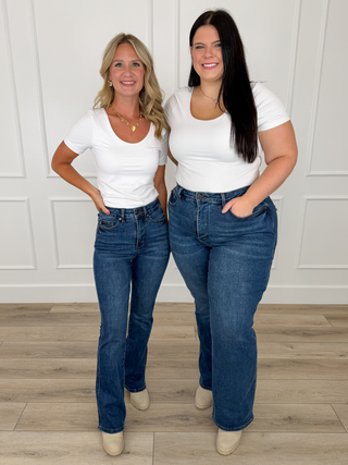 White scoop neck short sleeve top paired with Judy Blue Cali dark wash bootcut jeans and cream booties.