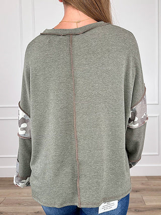 Green long sleeve top back view with long seam detail and camouflage sleeve bands.