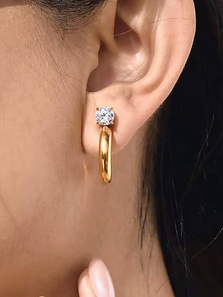 Gold hoop earrings with a round crystal accent near the hinge