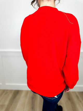 Red knit long-sleeve pullover top with rounded back and curved hem