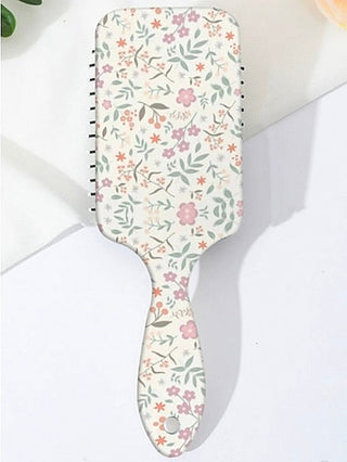 Floral detangling hair brush with colorful print on a white paddle handle