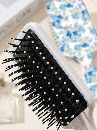 Black detangling hair brush with white bristle tips and white handle